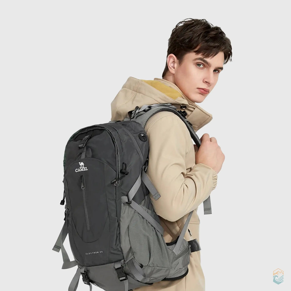 Male model wearing a dark gray Camel 40L waterproof hiking backpack, showcasing its sleek design and comfortable fit, perfect for outdoor adventures and trekking.