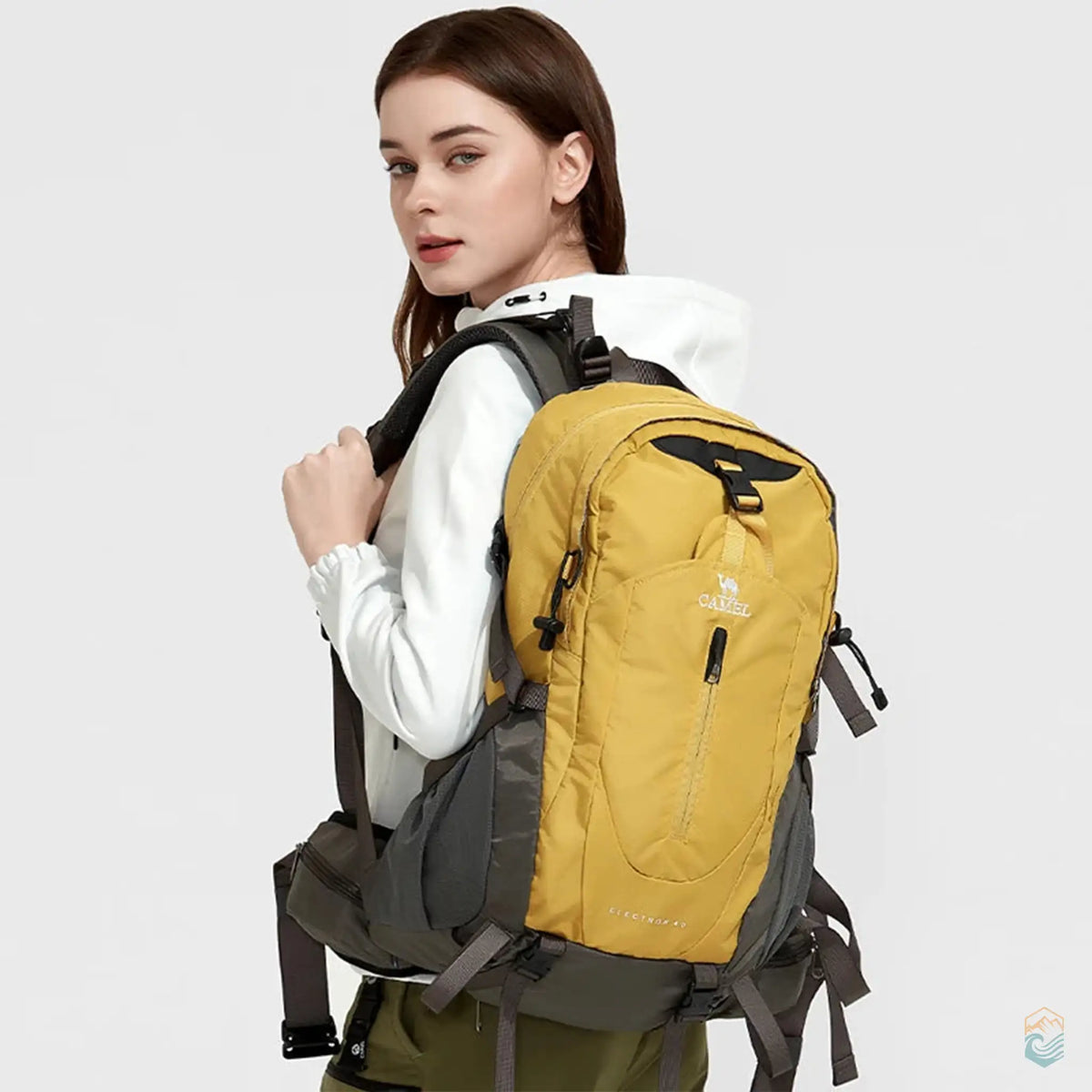 Model wearing a honey Camel 40L waterproof hiking backpack, showcasing its ergonomic design and comfortable fit, ideal for outdoor enthusiasts and adventurers.