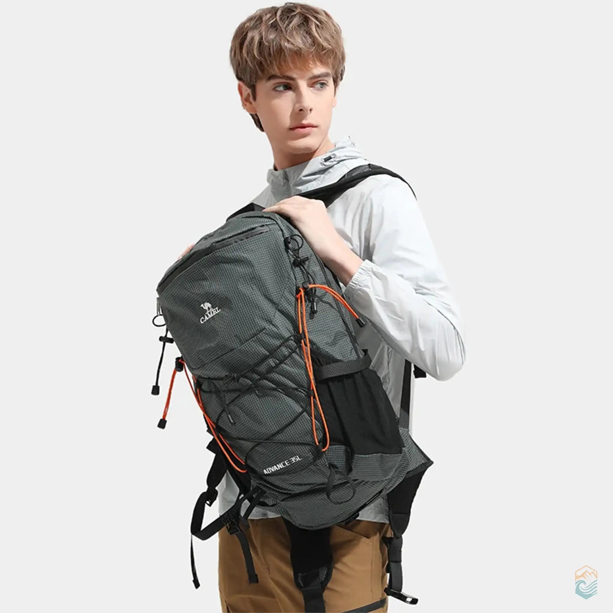 Man wearing Camel outdoor backpack in gray, showcasing the ergonomic design and adjustable straps, perfect for hiking and outdoor adventures.