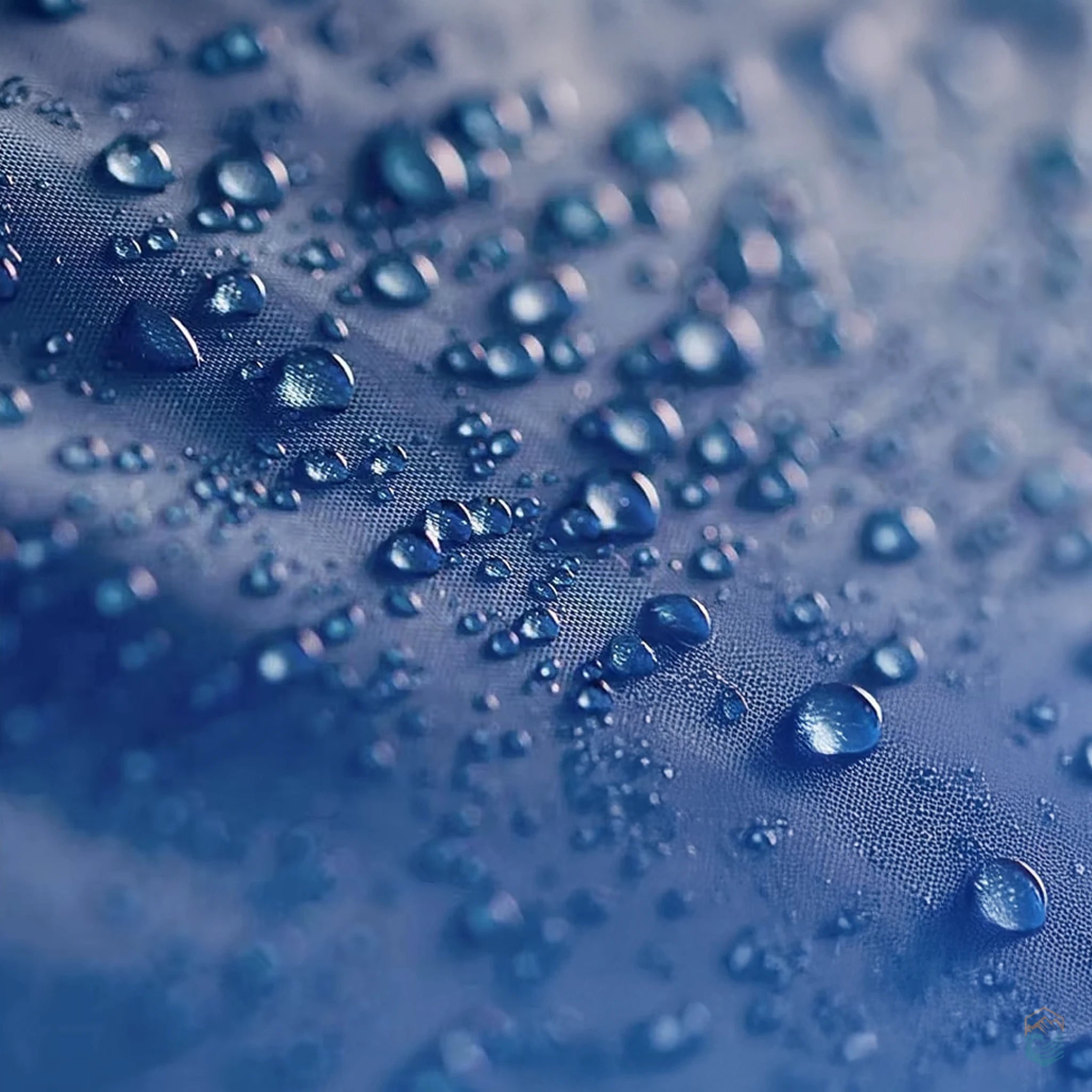 Close-up of blue waterproof fabric with water droplets beading on the surface, demonstrating water resistance of the Pacific Pass tent material