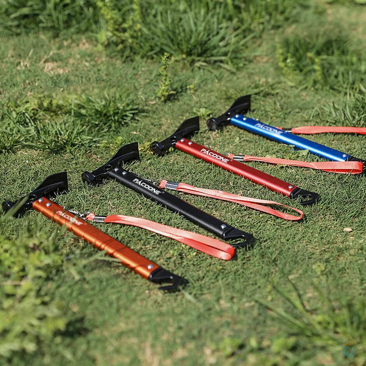 Pacoone camping hammer multi-tools in orange, black, red, and blue arranged on grassy field, showcasing durable construction, ergonomic shape, and color options for outdoor use