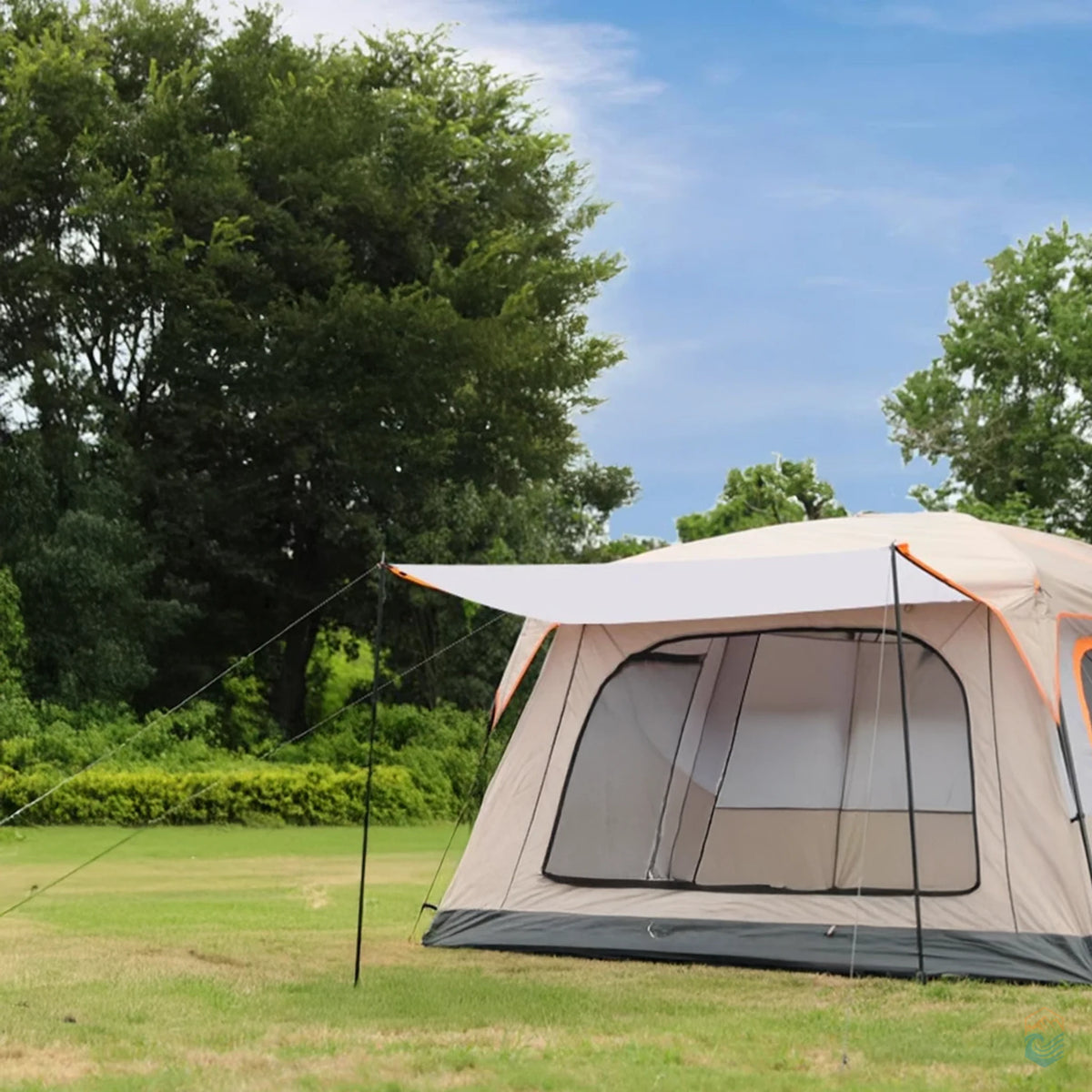 Khaki Sonuto family camping tent with canopy extended, pitched on a grassy field under a blue sky with trees in the background