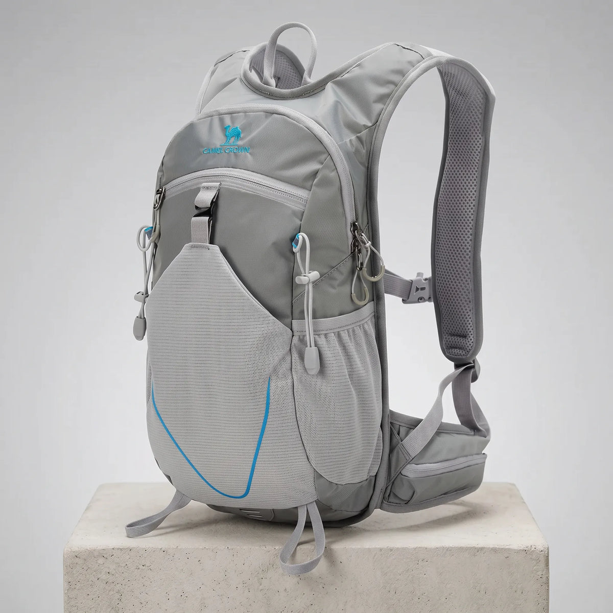 Camel 12L hiking backpack in gray with lightweight waterproof construction, breathable shoulder straps, front mesh storage pocket, side water bottle pockets, and ergonomic design for hiking, trekking, camping, cycling, trail running, travel, and outdoor adventures.