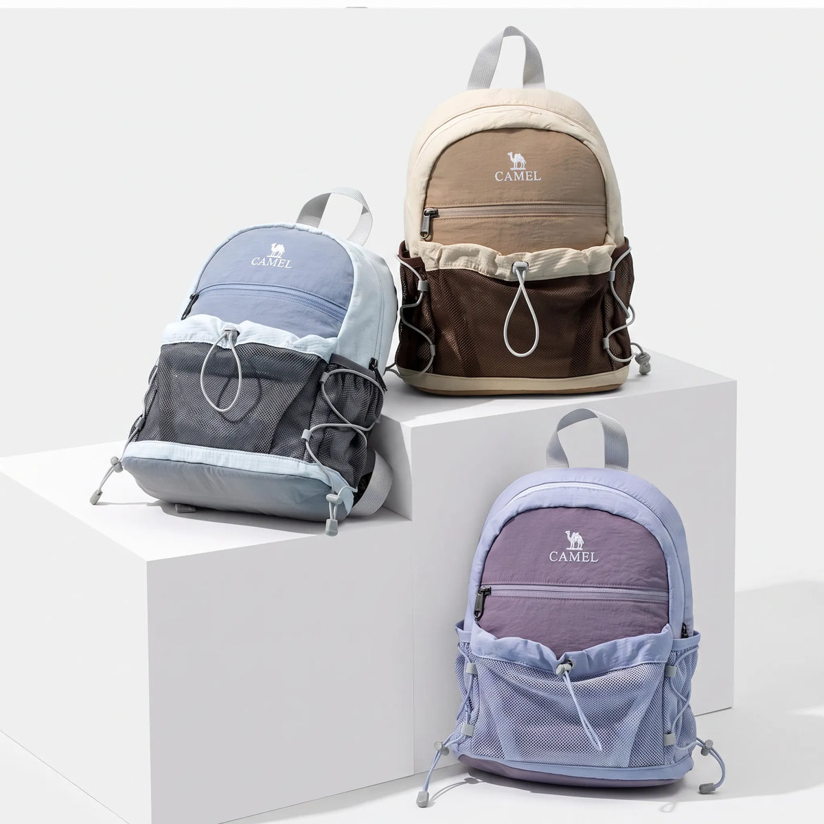 Golden Camel lightweight hiking backpacks displayed in blue, brown, and purple with front mesh storage pockets and adjustable cords.