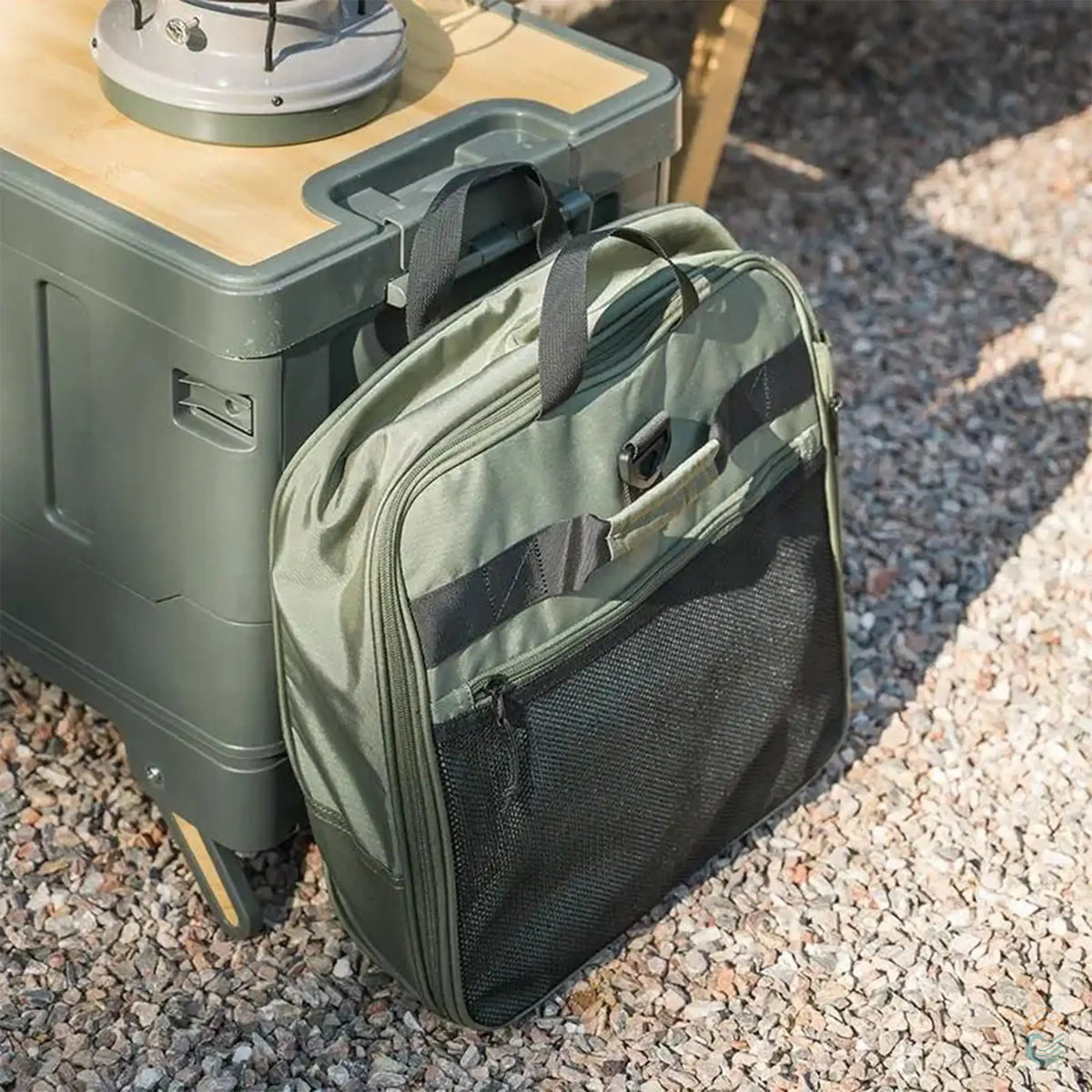 Lifestyle image of the green Naturehike foldable camping storage bag with wheels, shown in a campsite setting next to camping gear. The bag is compact and practical, ideal for organizing and transporting outdoor essentials.