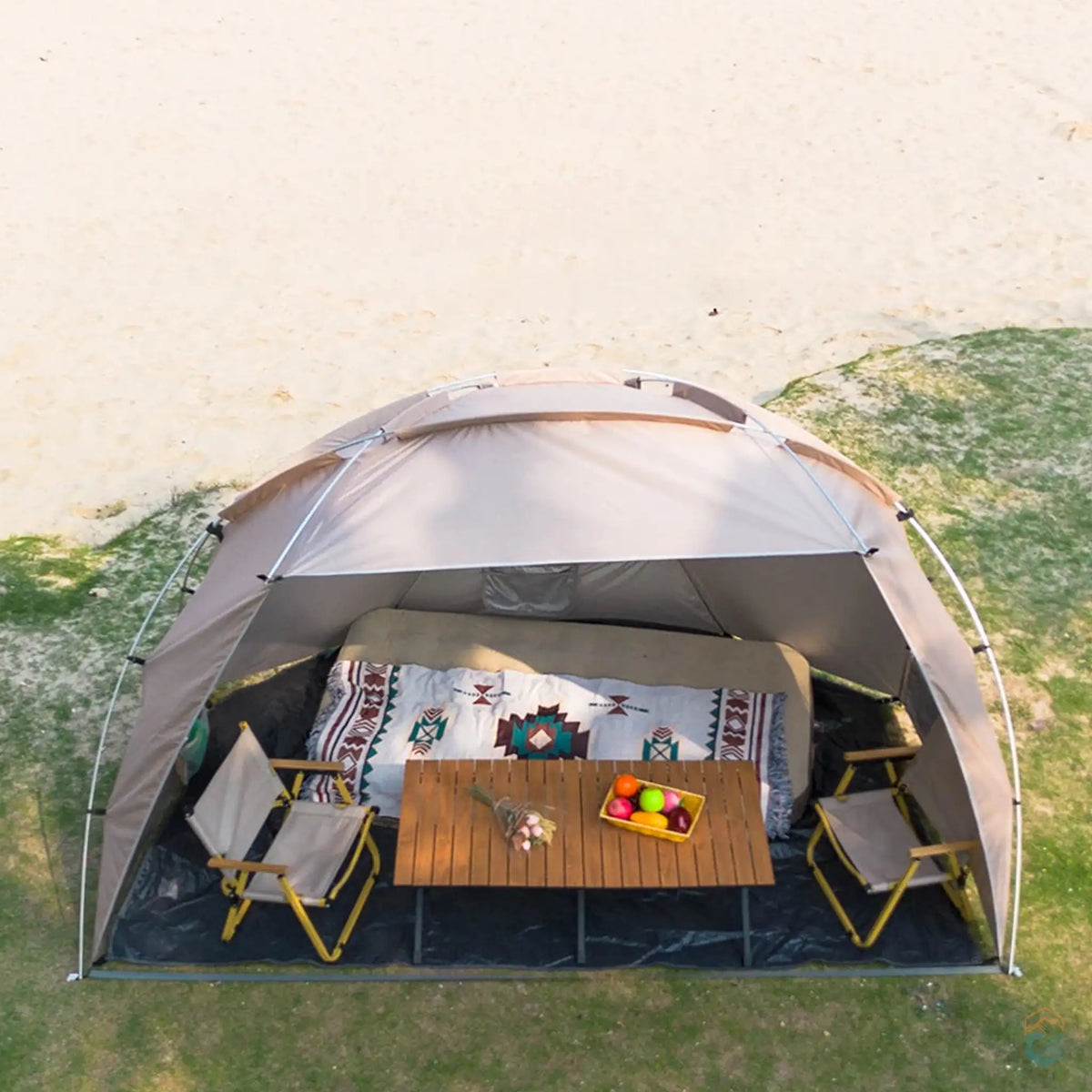 Aerial view of the khaki Sonuto beach shelter tent with a semi-open design, providing a spacious 5.4m² shaded area. The tent is set up for a relaxing camping experience, featuring chairs and a table under the shade, ideal for beach outings and picnics.