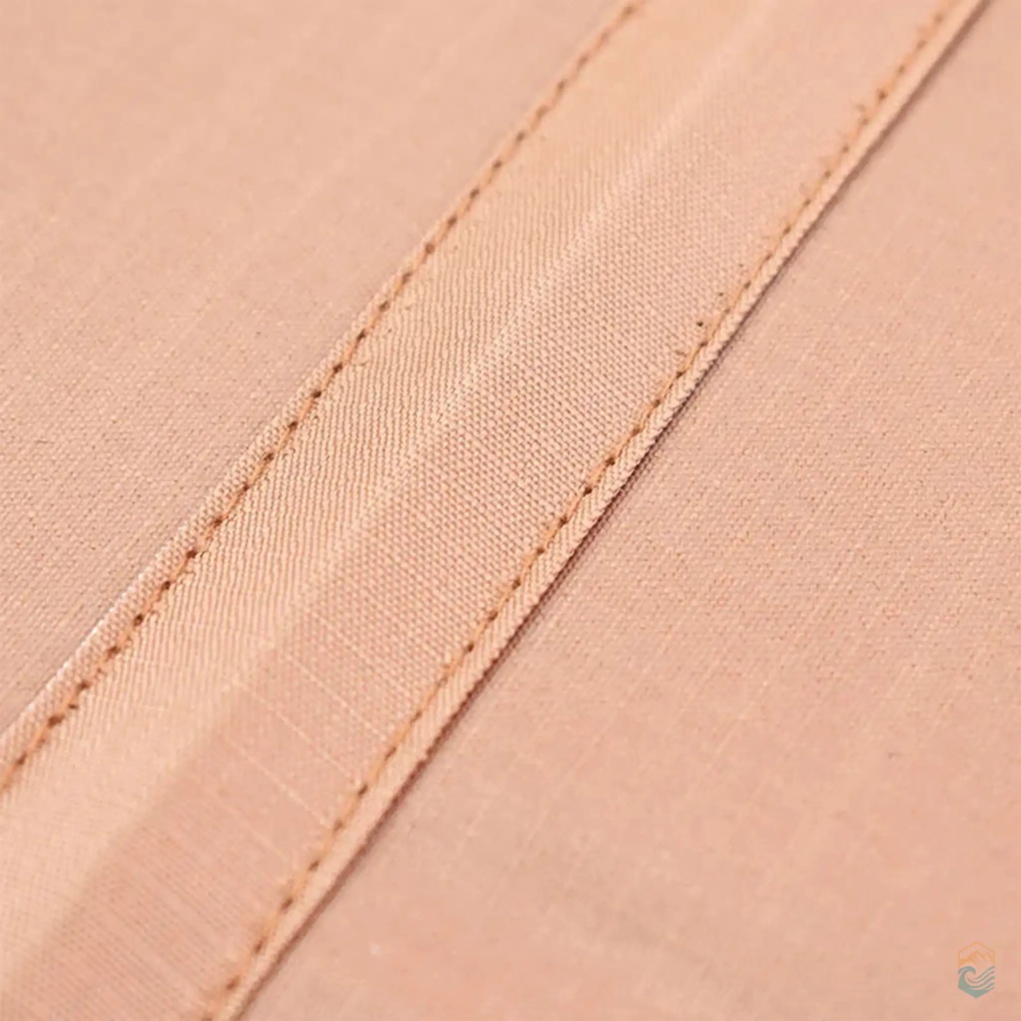 Close-up detail of the sand-colored fabric on a collapsible camping table, highlighting the stitching and material quality, ideal for outdoor durability and comfort.