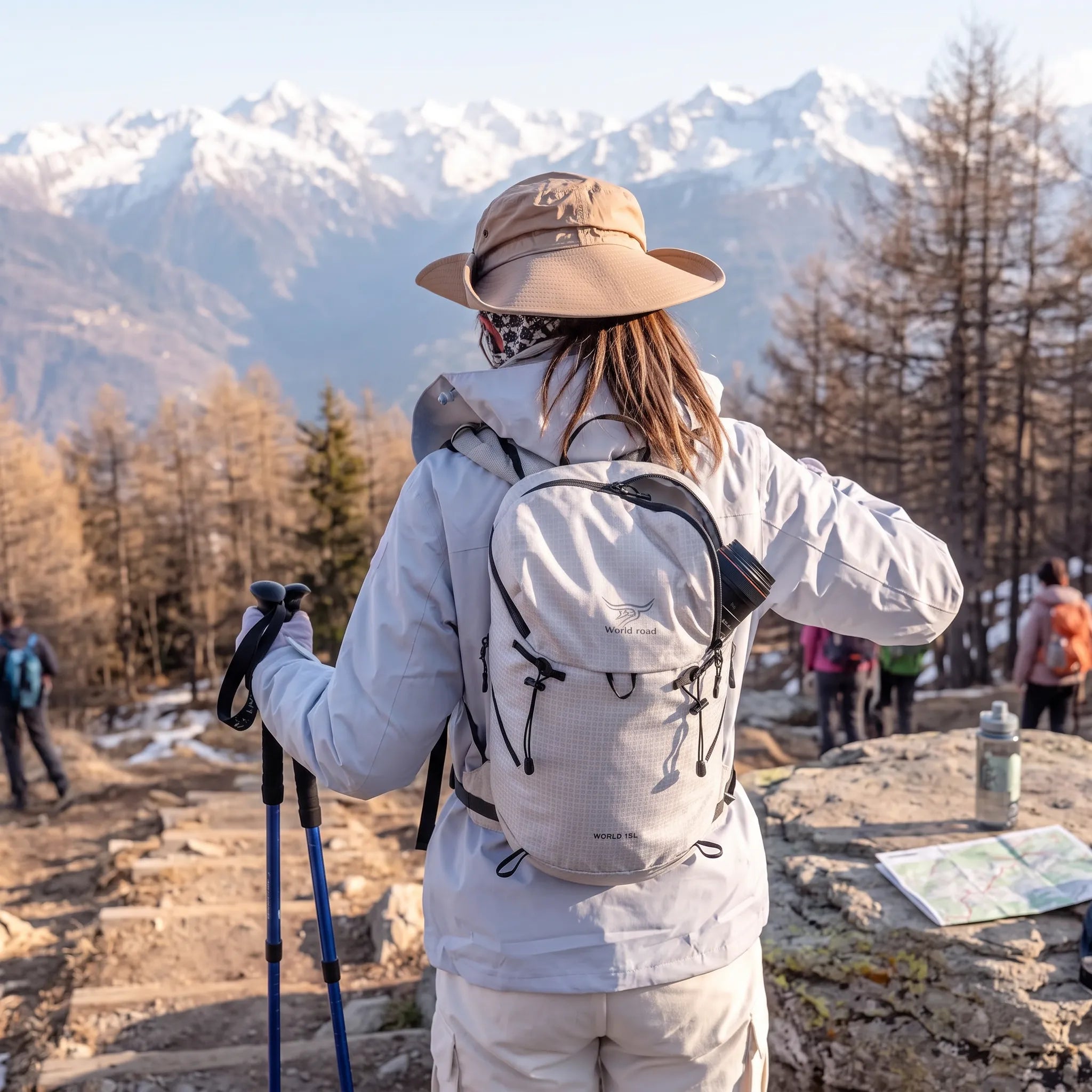 Woman wearing the white World Road 15L Urban Outdoor Hiking Backpack while hiking on a mountain trail with trekking poles.