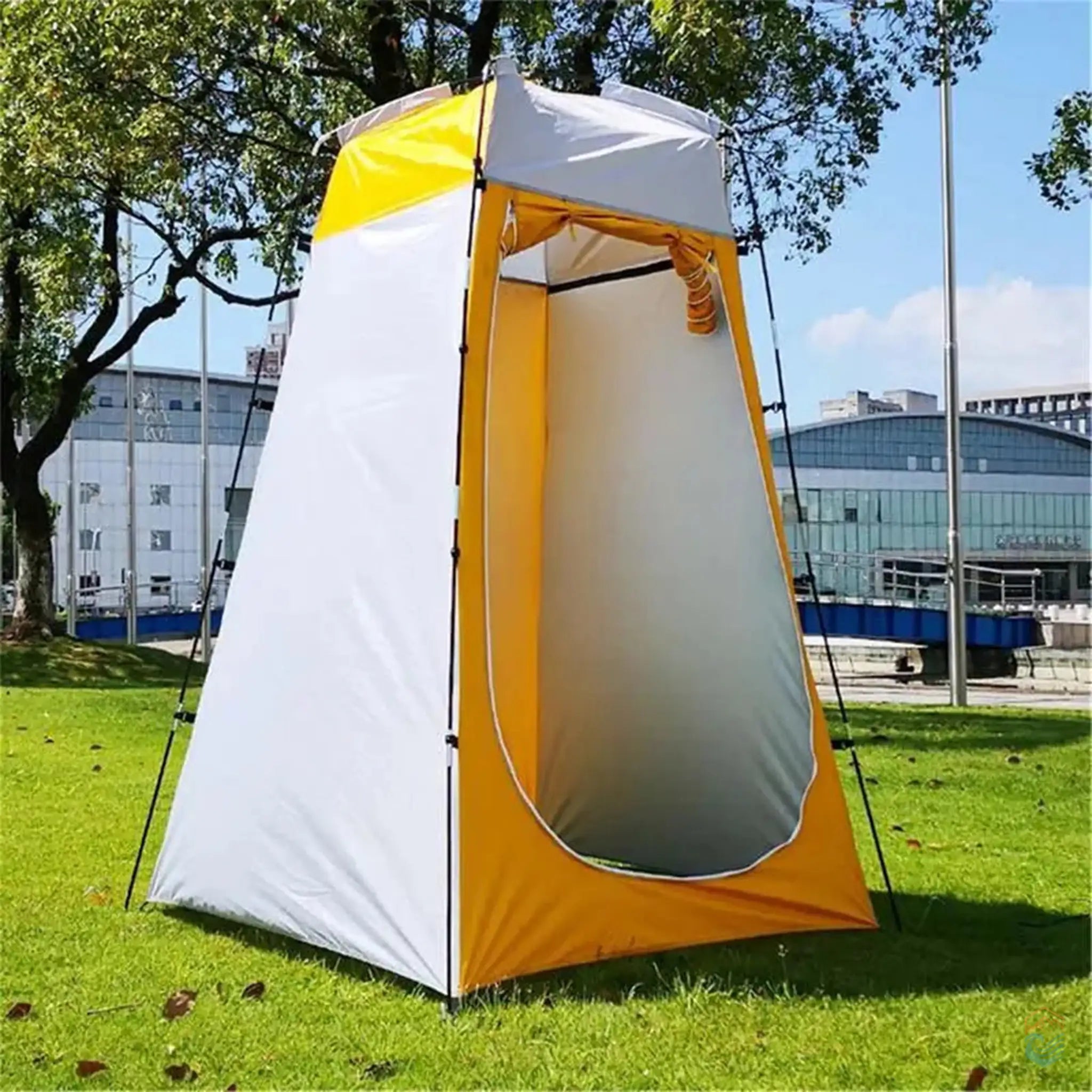 Yellow portable shower tent set up outdoors on a grassy area, showcasing its durable structure and spacious interior, ideal for camping and outdoor activities.